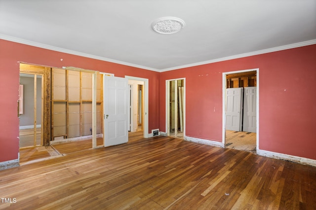 unfurnished bedroom with crown molding and wood-type flooring