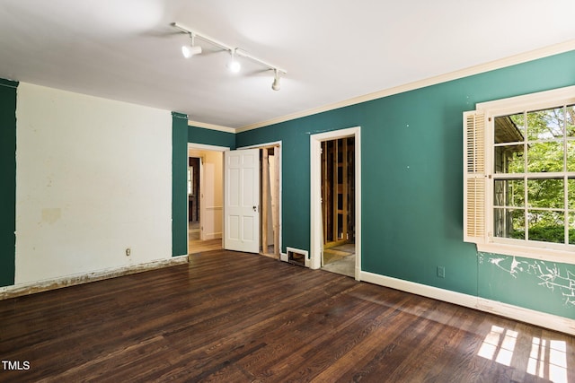 unfurnished room featuring ornamental molding, rail lighting, and dark hardwood / wood-style flooring