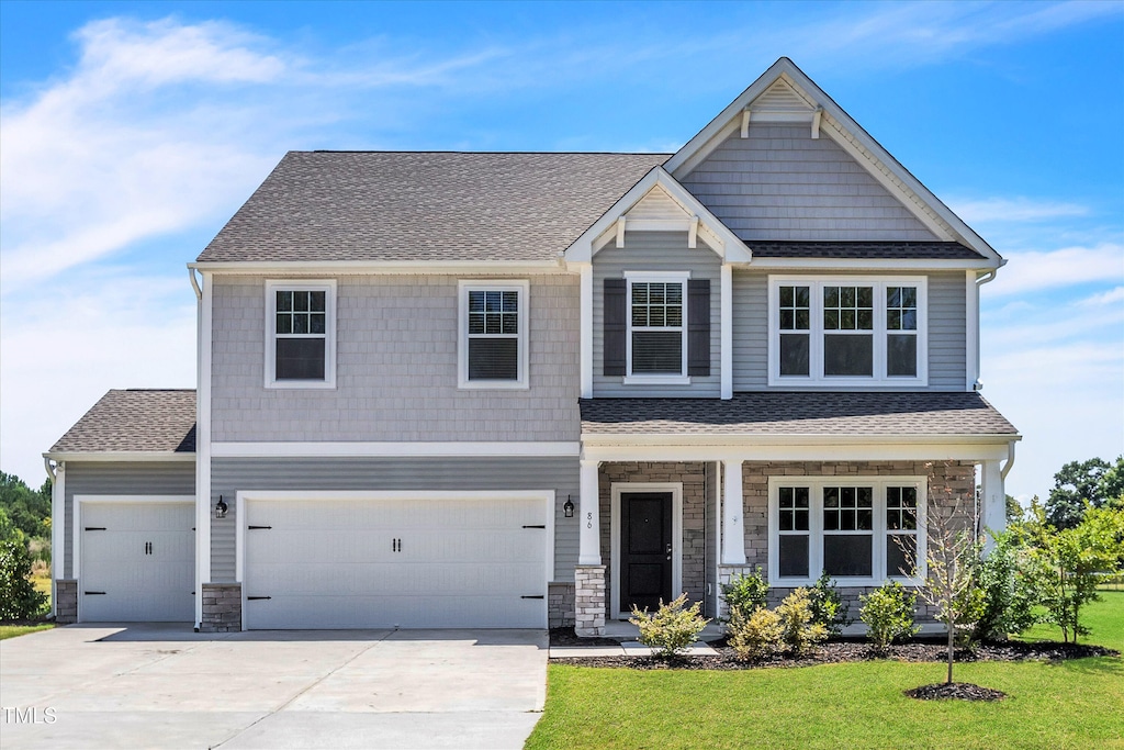 craftsman-style home featuring a front yard and a garage