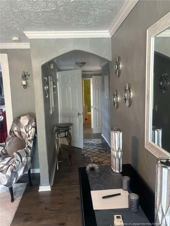 hallway featuring ornamental molding, a textured ceiling, and dark hardwood / wood-style floors