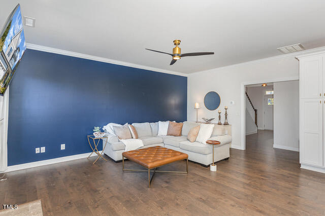 living room with crown molding, ceiling fan, and dark hardwood / wood-style flooring