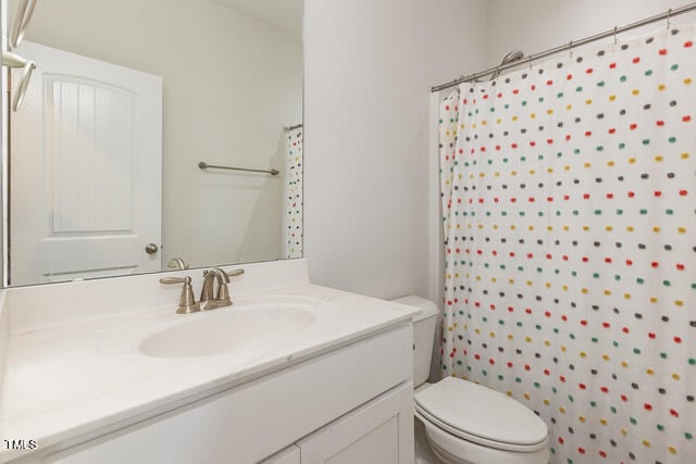 bathroom with toilet, curtained shower, and vanity