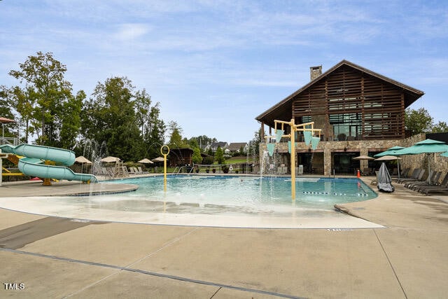 view of swimming pool featuring a water slide and pool water feature