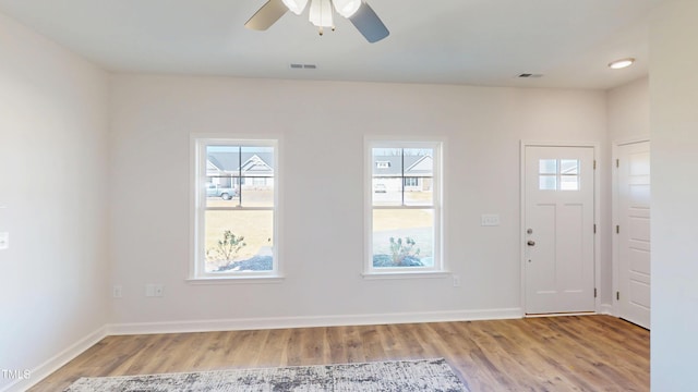 entrance foyer featuring visible vents, a wealth of natural light, ceiling fan, and wood finished floors