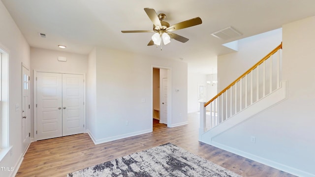 interior space featuring visible vents, baseboards, a ceiling fan, and wood finished floors