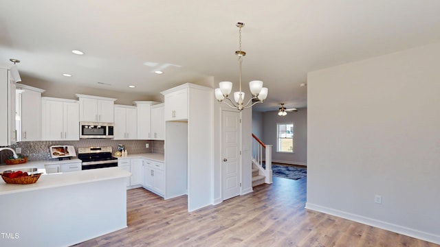 kitchen with tasteful backsplash, light wood finished floors, a sink, and appliances with stainless steel finishes