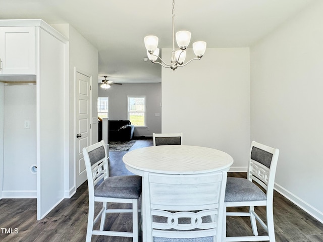 dining space with dark wood-style flooring, baseboards, and ceiling fan with notable chandelier