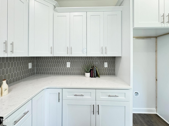 kitchen featuring white cabinetry, baseboards, and backsplash