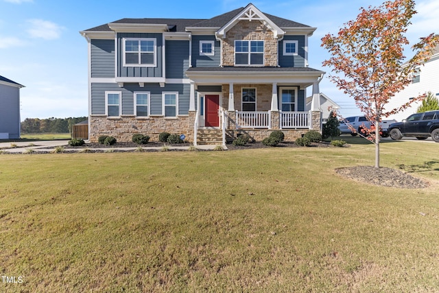 craftsman house featuring covered porch and a front yard