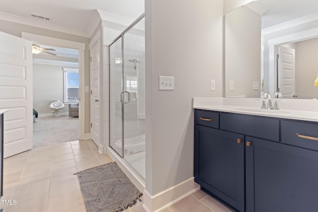 bathroom with ceiling fan, vanity, tile patterned flooring, ornamental molding, and a shower with door