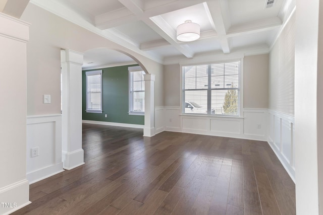 spare room with beamed ceiling, dark hardwood / wood-style floors, decorative columns, crown molding, and coffered ceiling