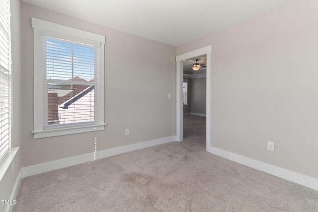 spare room featuring ceiling fan and light carpet