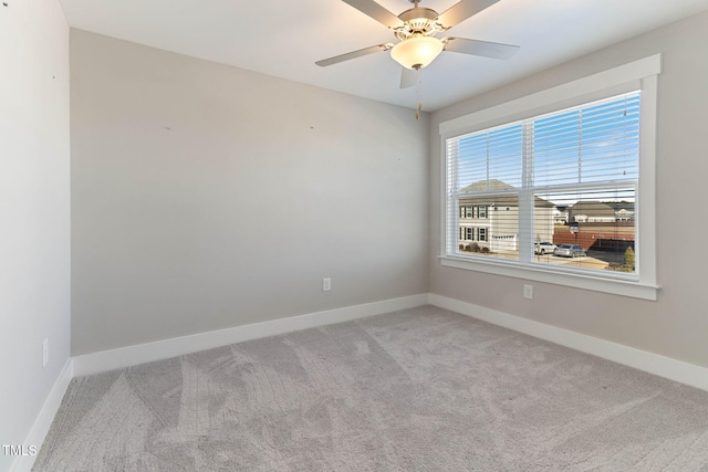 carpeted spare room with ceiling fan