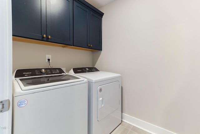 laundry area featuring cabinets, light tile patterned floors, and independent washer and dryer