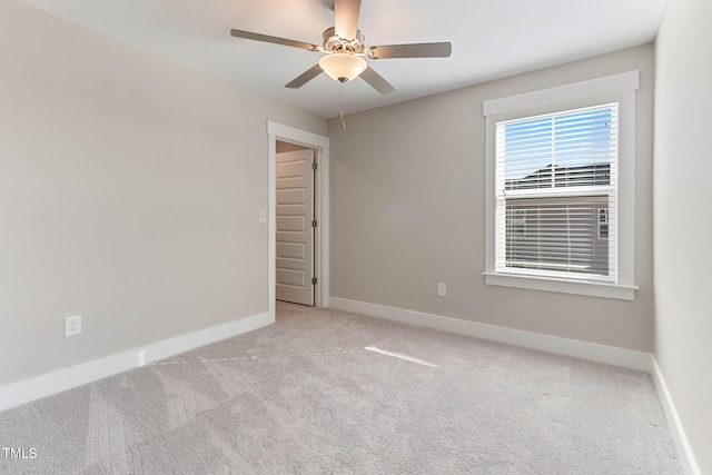 empty room with ceiling fan and light carpet