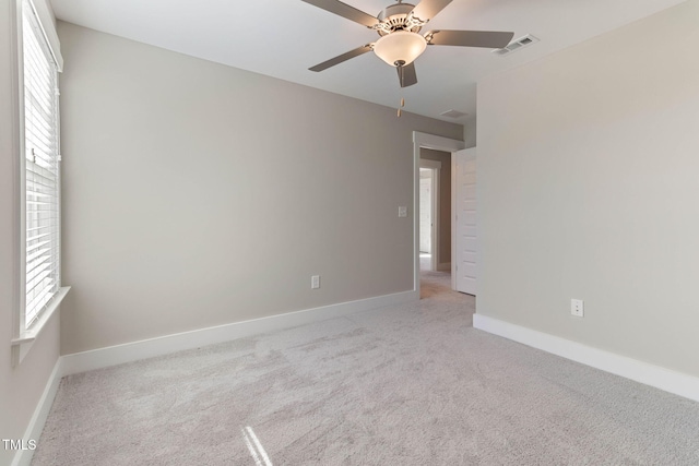 carpeted spare room with ceiling fan