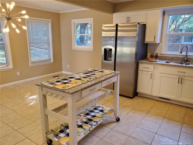 kitchen featuring sink, light stone countertops, a notable chandelier, white cabinetry, and stainless steel fridge with ice dispenser