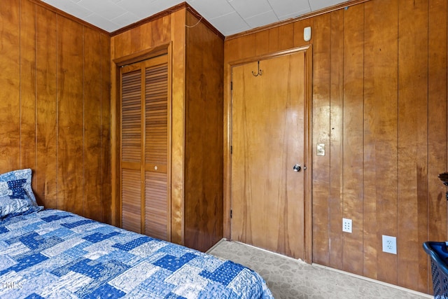 bedroom with a closet and wooden walls