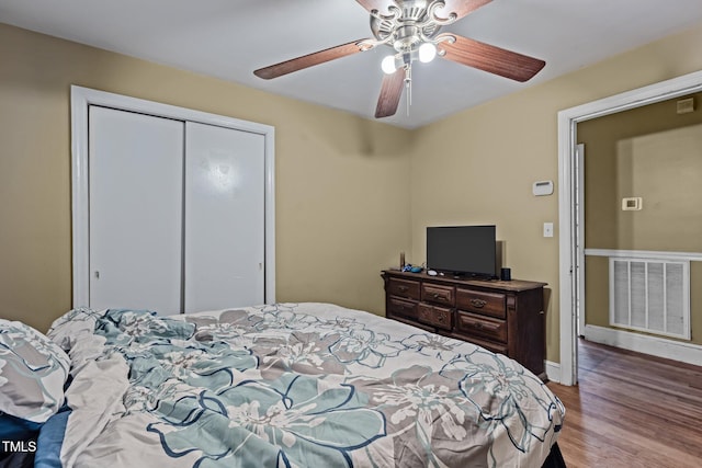 bedroom with hardwood / wood-style floors, a closet, and ceiling fan