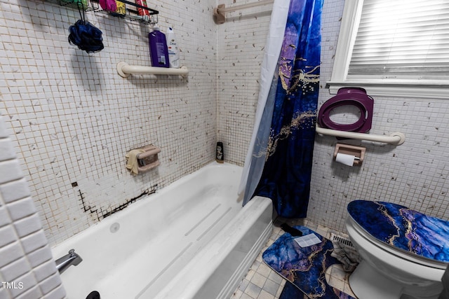 bathroom with tile walls, shower / tub combo with curtain, toilet, and tile patterned flooring