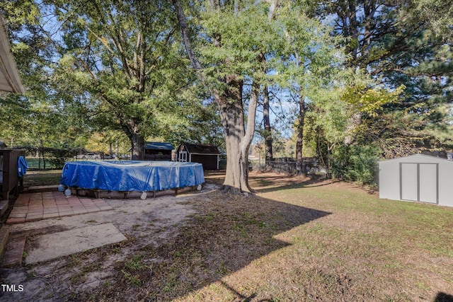 view of yard with a storage shed and a covered pool