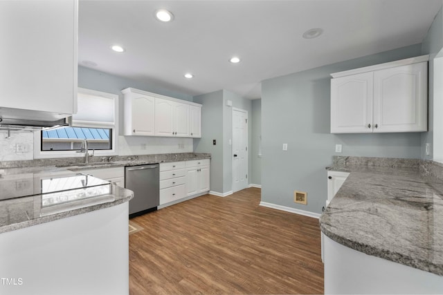 kitchen featuring white cabinets, light stone counters, hardwood / wood-style flooring, stainless steel dishwasher, and sink