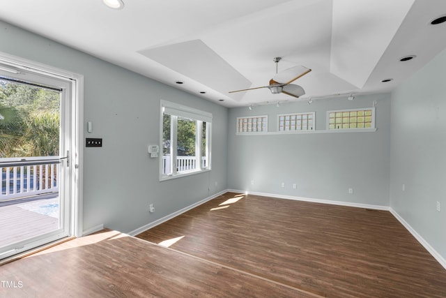 spare room with ceiling fan, a healthy amount of sunlight, and dark hardwood / wood-style floors