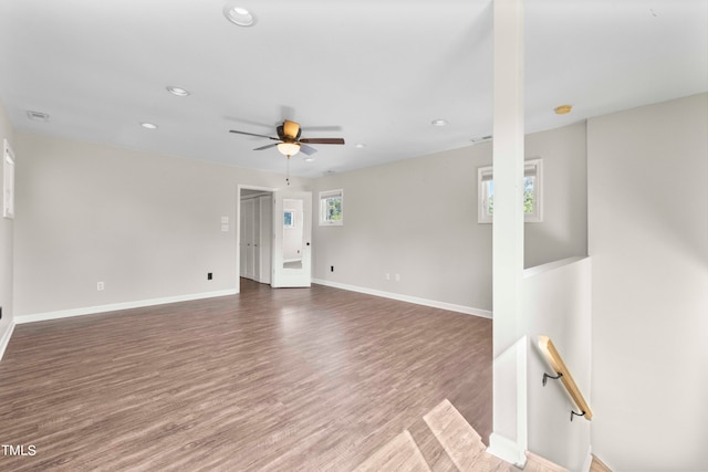 empty room with wood-type flooring, plenty of natural light, and ceiling fan