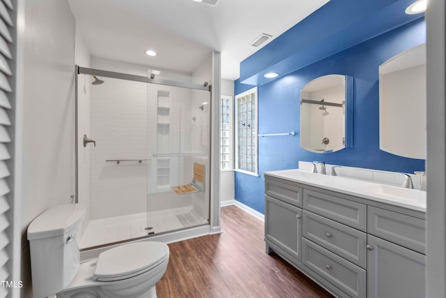 bathroom featuring vanity, a shower with shower door, wood-type flooring, and toilet