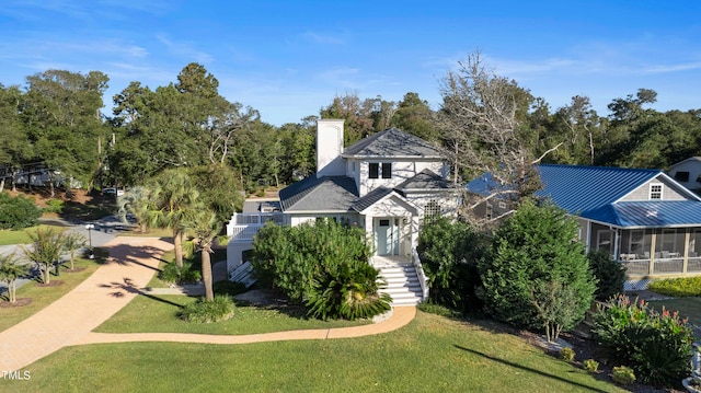 view of front facade with a front yard and a sunroom