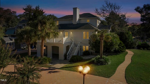 back house at dusk with a lawn