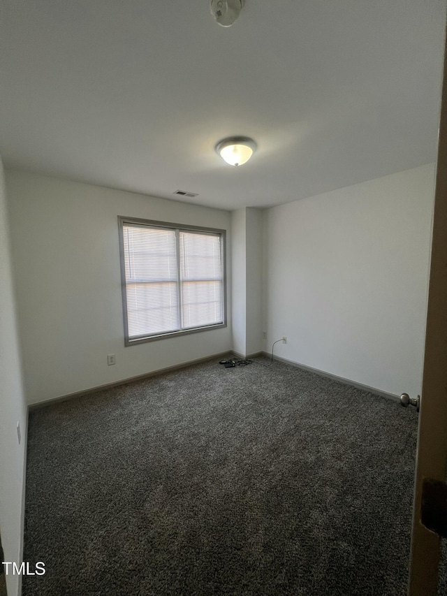 unfurnished room with dark carpet