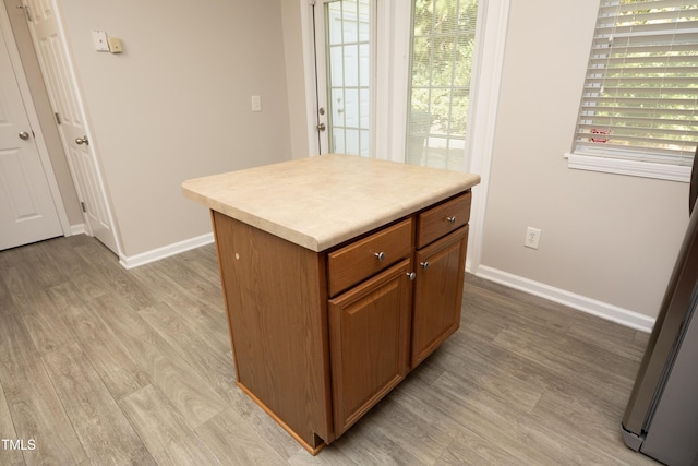 kitchen with a center island, a wealth of natural light, and light wood-type flooring