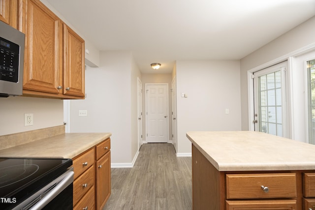 kitchen with appliances with stainless steel finishes and light hardwood / wood-style flooring