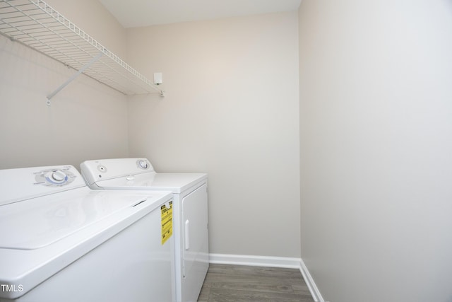 clothes washing area with washing machine and dryer and hardwood / wood-style floors