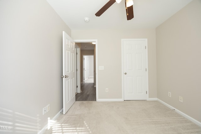 unfurnished bedroom featuring light colored carpet and ceiling fan