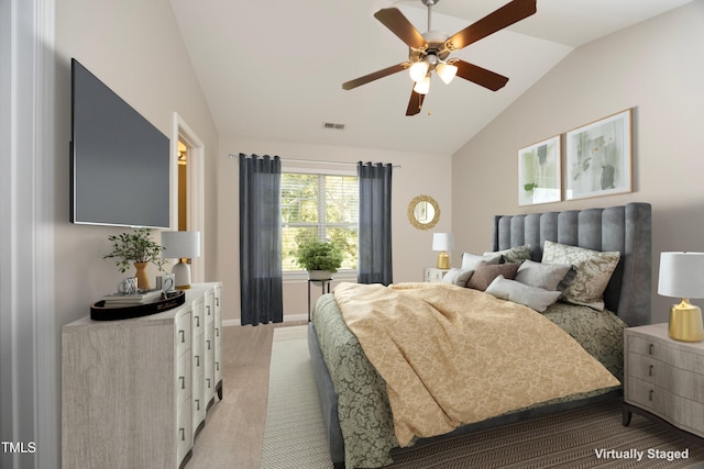 bedroom with ceiling fan, lofted ceiling, and light carpet