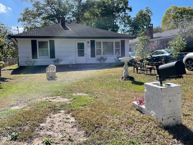 rear view of property with a lawn