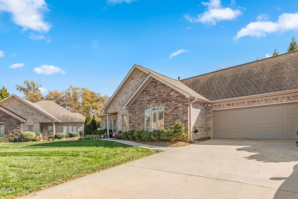 view of front of property featuring a garage and a front lawn