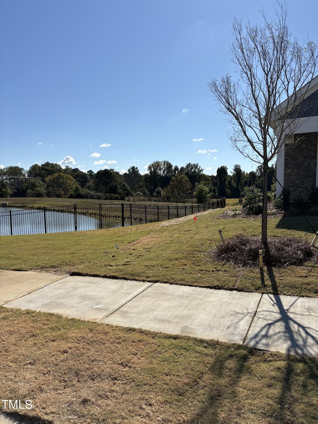 view of yard featuring fence and a water view