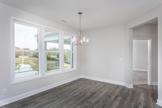 unfurnished room with a chandelier, dark hardwood / wood-style flooring, and a water view