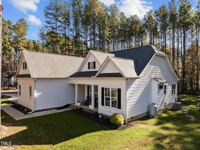 view of front of home with a front yard, cooling unit, and a porch