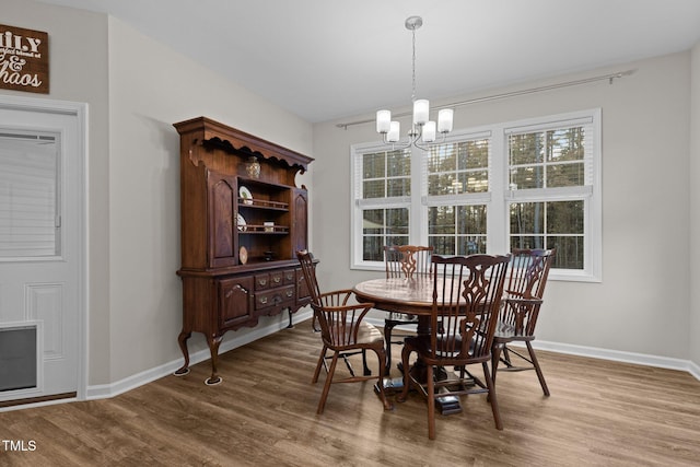 dining room featuring wood-type flooring and a notable chandelier