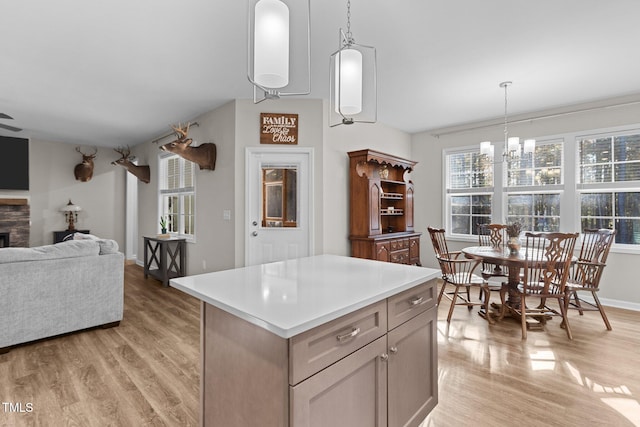 kitchen featuring light hardwood / wood-style flooring, decorative light fixtures, and a center island