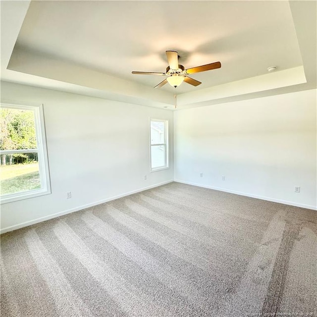 145 Cahill, Home, Raeford, NC 28376 - carpeted spare room featuring ceiling fan, a tray ceiling, baseboards, and plenty of natural light