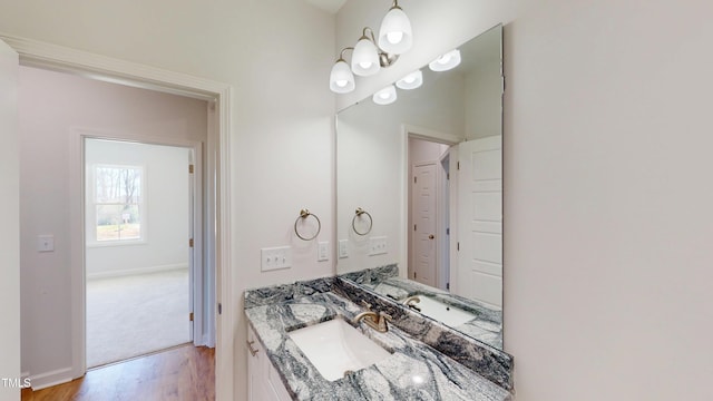 bathroom featuring baseboards, wood finished floors, and vanity