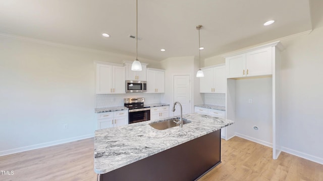kitchen with a sink, backsplash, stainless steel appliances, and white cabinetry