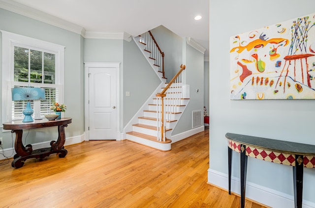 staircase featuring ornamental molding and hardwood / wood-style floors