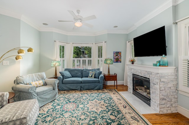 living room with ceiling fan, ornamental molding, light hardwood / wood-style flooring, and a fireplace