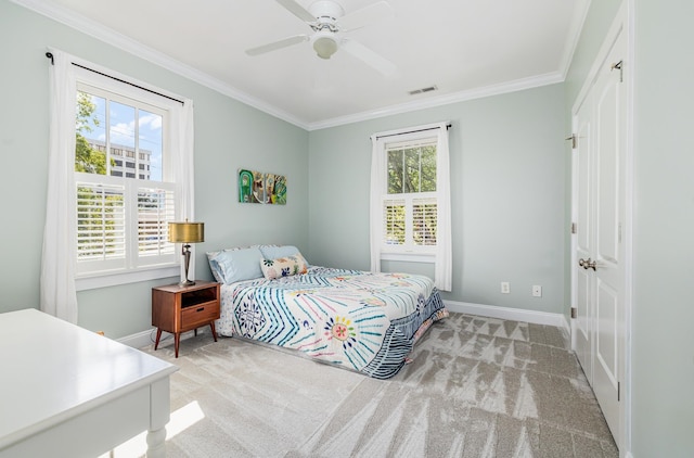 bedroom featuring multiple windows, light colored carpet, and ceiling fan